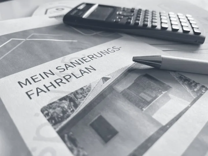 Individueller Sanierungsfahrplan – Energieberatung München vom Energieeffizienz-Experten Beispiel eines individuellen Sanierungsfahrplans für die energetische Sanierung einer Immobilie, erstellt von einem Energieeffizienz-Experten München mit Taschenrechner und Stift.