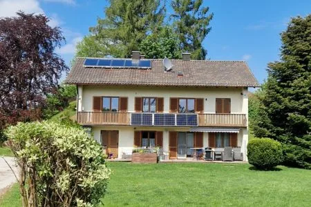 Energieeffizienz-Experte München: Sanierungspotenzial eines Mehrfamilienhauses in Oberbayern Unsaniertes Mehrfamilienhaus in Oberbayern mit Photovoltaikanlage und Potenzial für energetische Modernisierung durch Energieberatung München.