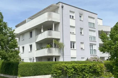 Energieeffizienz-Experte München: Erfolgreiche Sanierung eines Mehrfamilienhauses Modernisiertes Mehrfamilienhaus in München mit grauer Fassade und optimierter Energieeffizienz durch Energieberatung München.