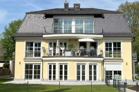 Energieeffizienz-Experte München: Sanierung eines modernen Mehrfamilienhauses in Gelb Modernes gelbes Mehrfamilienhaus in München, energieeffizient saniert durch einen Energieeffizienz-Experten München und umfassende Energieberatung München.