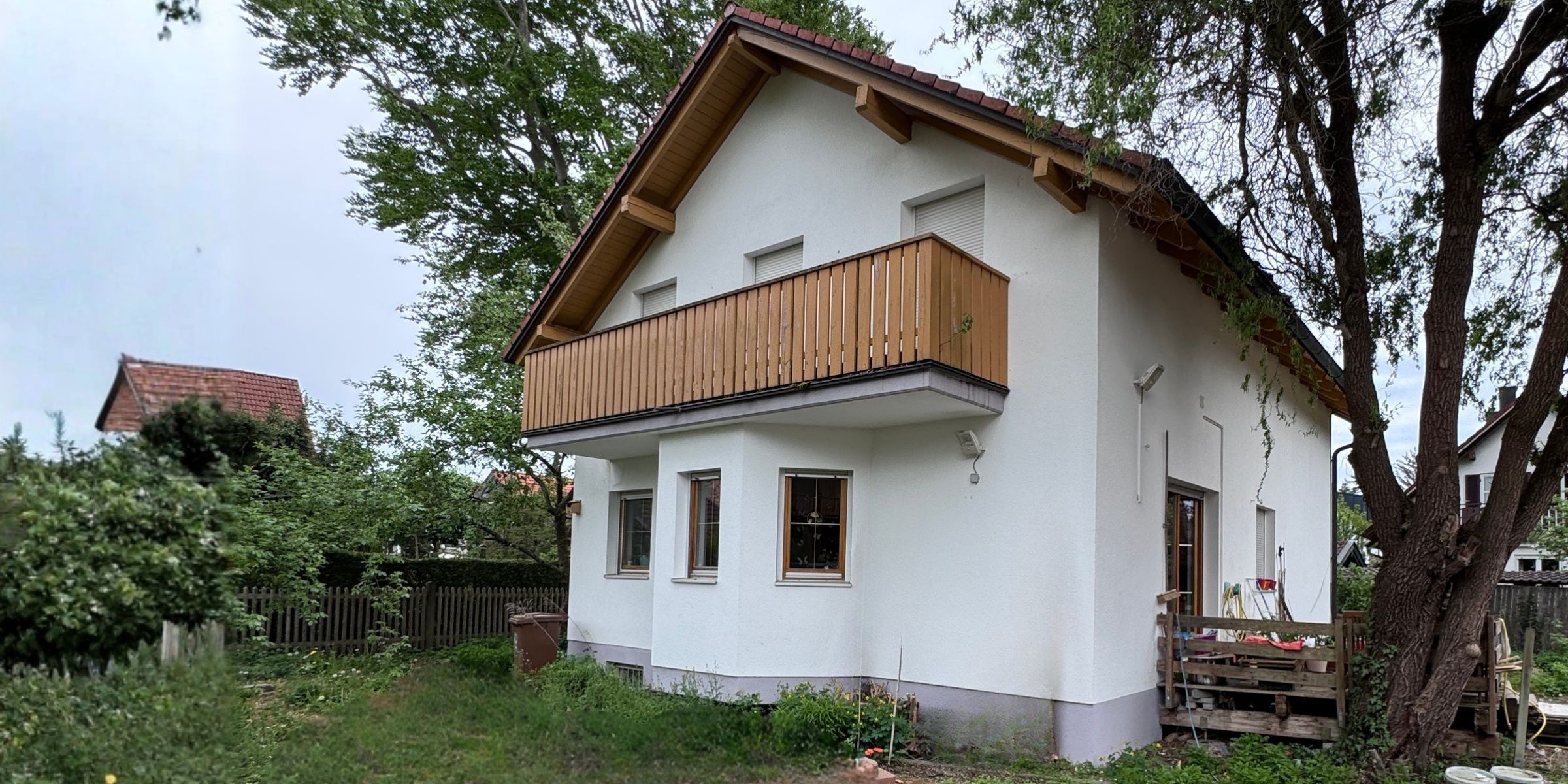 einfamilienhaus-muenchen-modern-schwarz-1970-scaled Blick auf ein Einfamilienhaus in München aus den 1970er Jahren mit moderner Architektut , weißen Wänden und schwarzen Giebeln