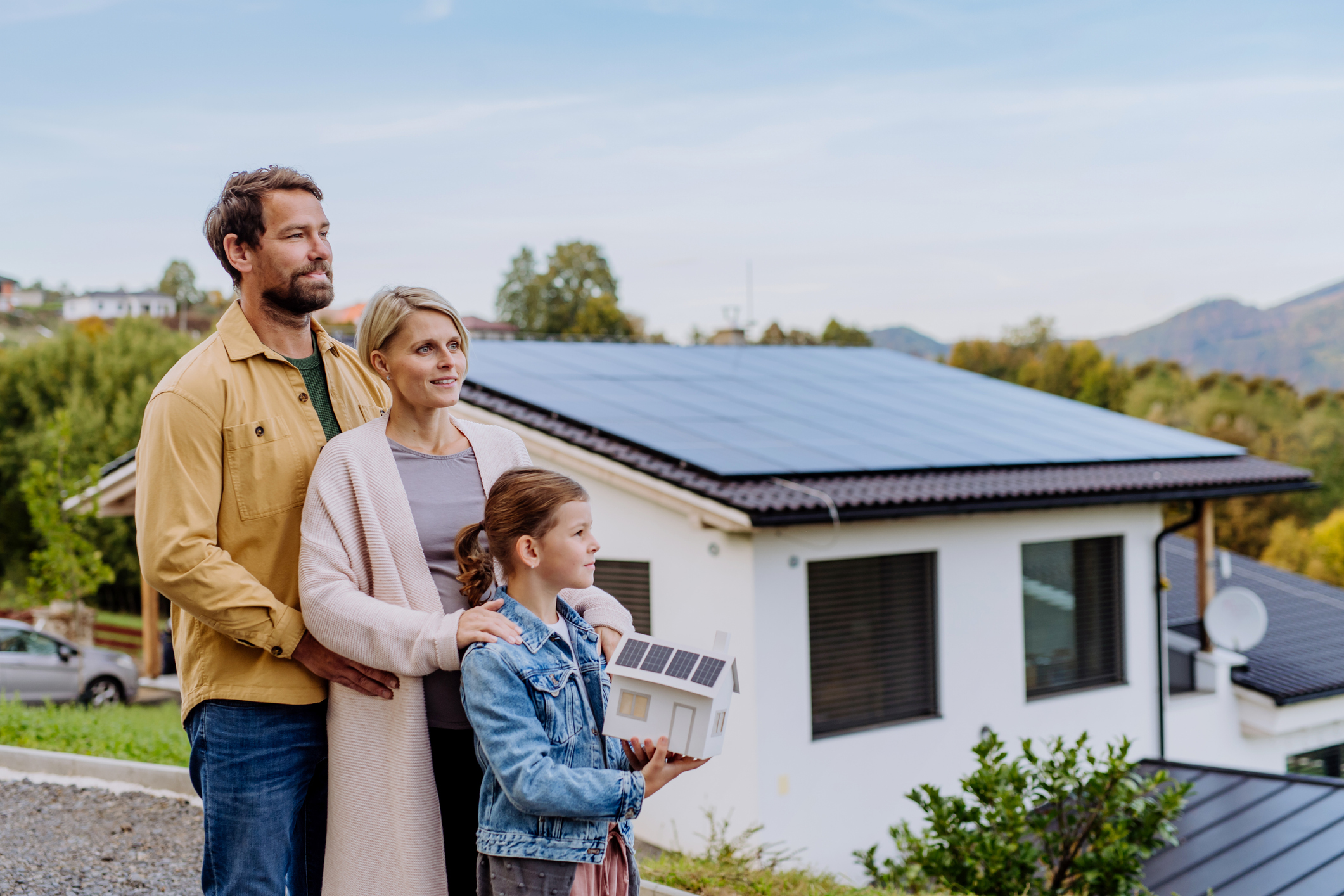 Familie vor einem Haus mit Solardach, unterstützt durch Photovoltaikberatung