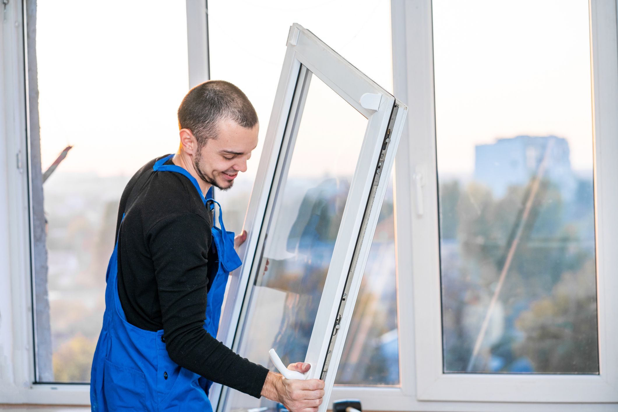 Handwerker bei der Fenstersanierung – Austausch eines alten Fensters