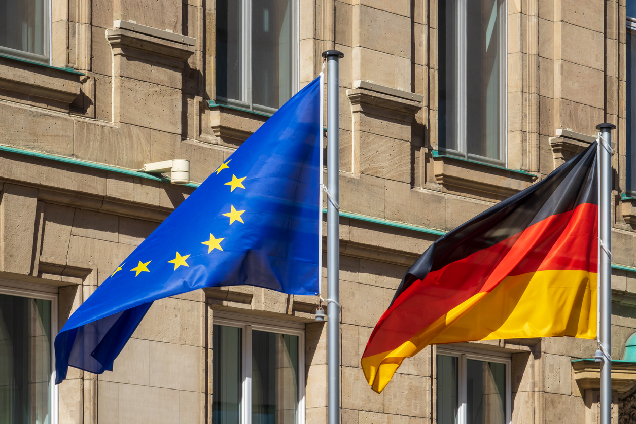 Europäische Gebäuderichtlinie und Gebäudeenergiegesetz - Europaflagge und deutsche Flagge vor historischem Gebäude