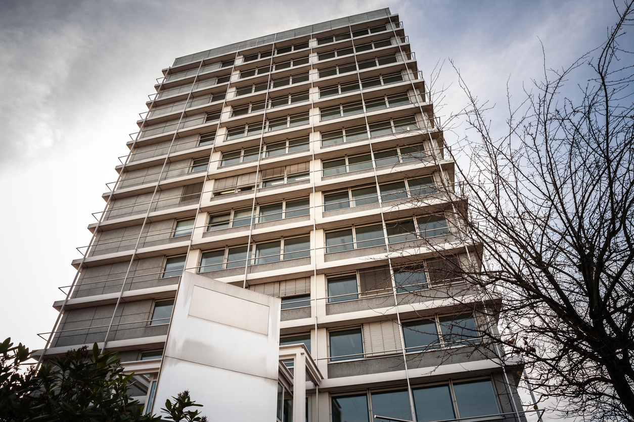 energieberatung Nichtwohngebäude: Blick von unten auf ein mehrstöckiges Büro- und Verwaltungsgebäude mit Fensterfassade