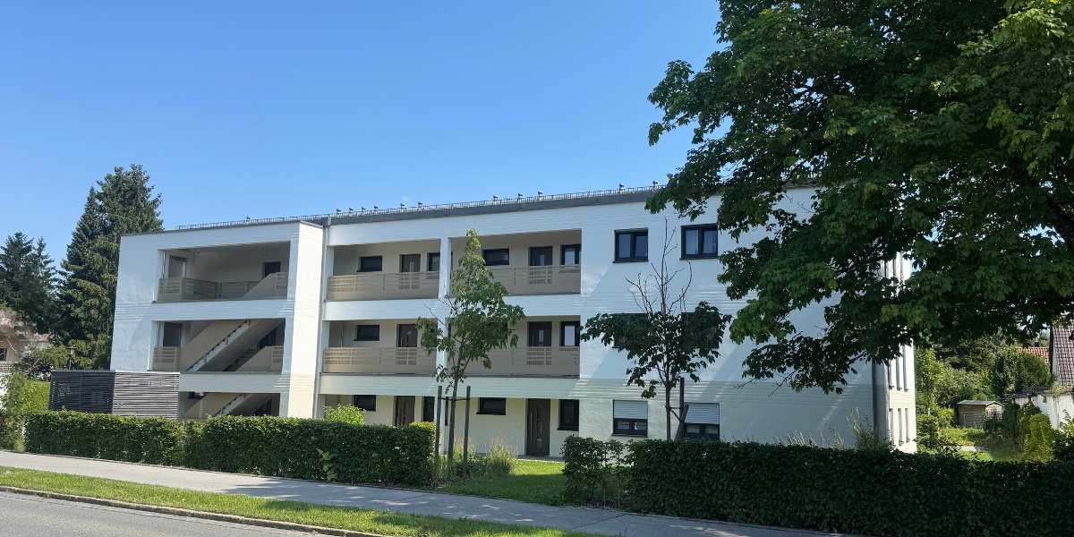 Unsaniertes Mehrfamilienhaus in Oberbayern mit Photovoltaikanlage und Potenzial für energetische Modernisierung durch Energieberatung München.