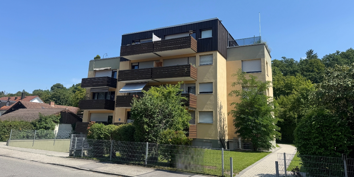 Unsaniertes Mehrfamilienhaus in Oberbayern mit Photovoltaikanlage und Potenzial für energetische Modernisierung durch Energieberatung München.