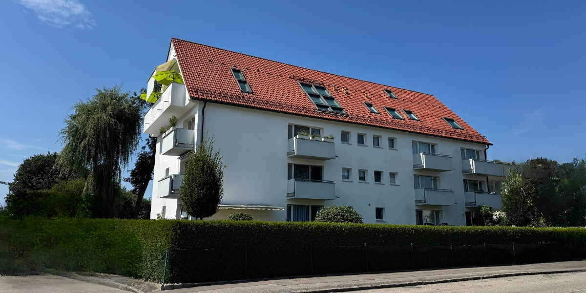 Unsaniertes Mehrfamilienhaus in Oberbayern mit Photovoltaikanlage und Potenzial für energetische Modernisierung durch Energieberatung München.