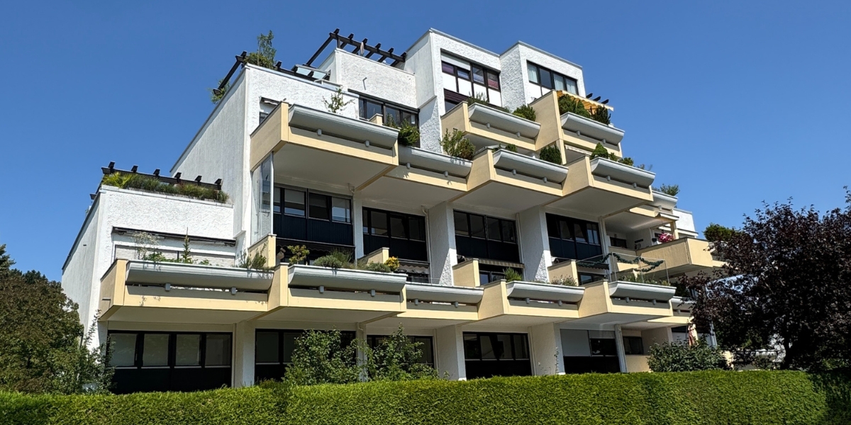 Unsaniertes Mehrfamilienhaus in Oberbayern mit Photovoltaikanlage und Potenzial für energetische Modernisierung durch Energieberatung München.