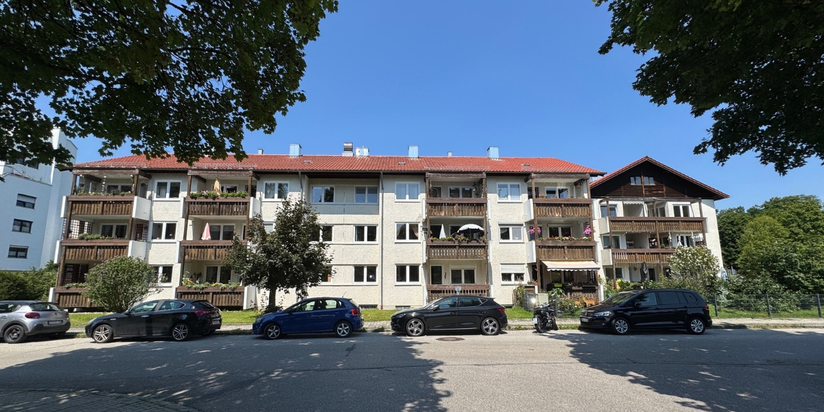 Unsaniertes Mehrfamilienhaus in Oberbayern mit Photovoltaikanlage und Potenzial für energetische Modernisierung durch Energieberatung München.