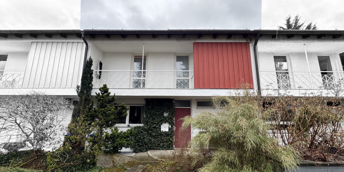 Blick auf ein Einfamilienhaus in München aus den 1970er Jahren mit moderner Architektut , weißen Wänden und schwarzen Giebeln
