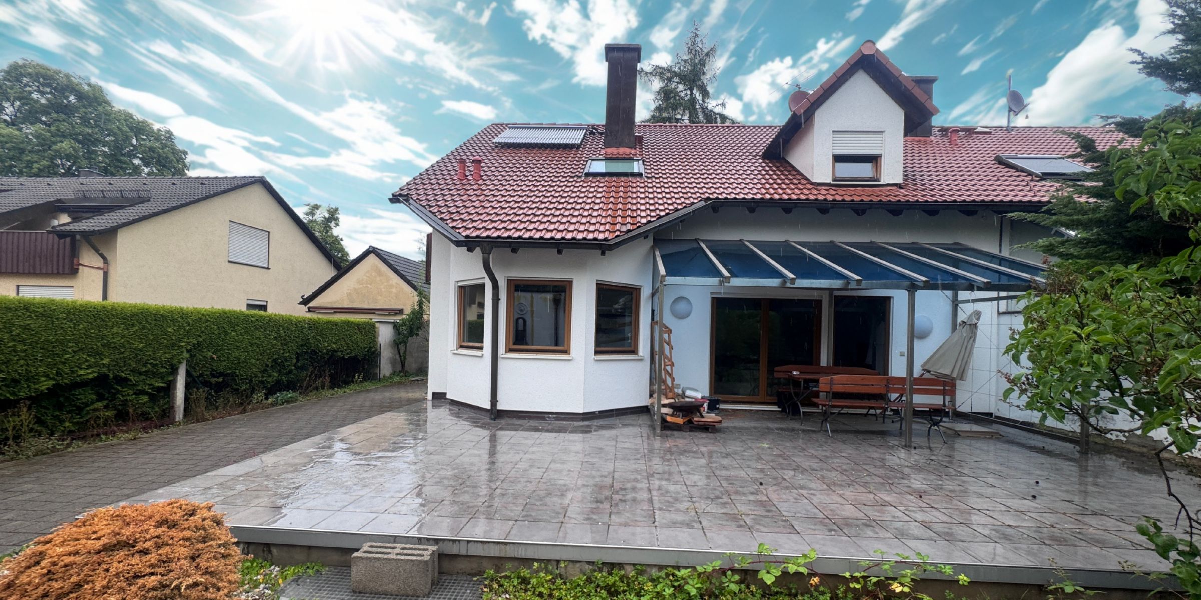 Blick auf ein Einfamilienhaus in München aus den 1970er Jahren mit moderner Architektut , weißen Wänden und schwarzen Giebeln
